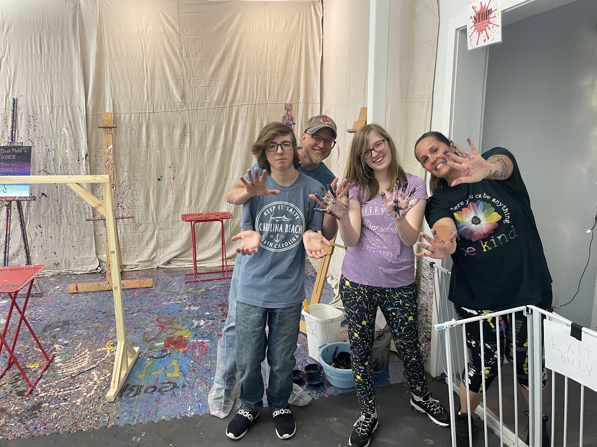 a family of four posing after splatter paint session