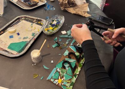 customer at art bar making a mosaic address marker.